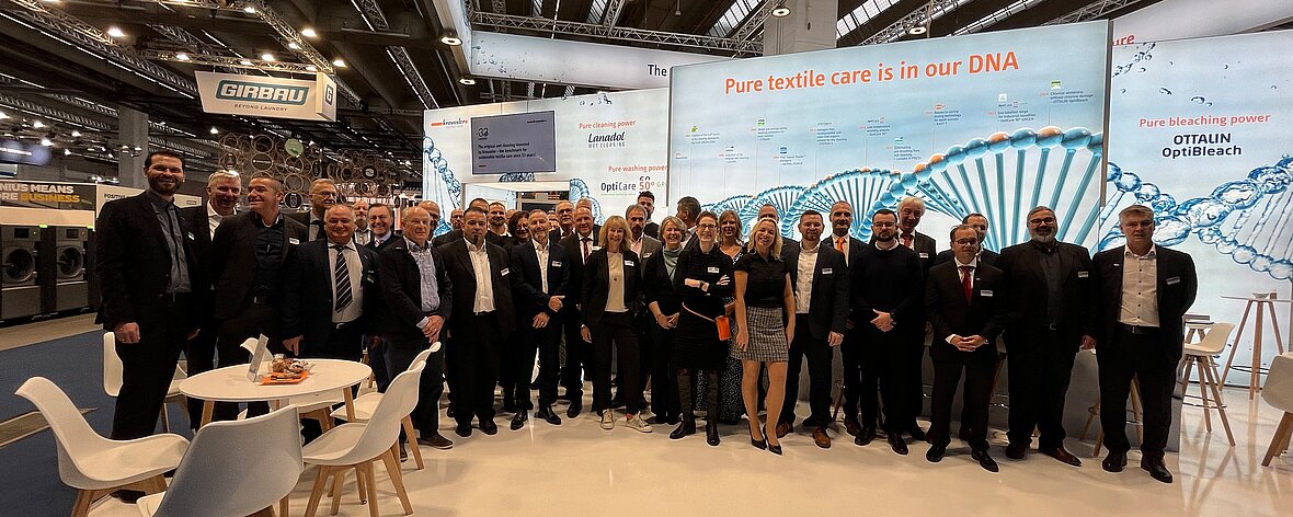 Gesamtes Messeteam von Kreussler Textile Care vor dem eigenen Messestand auf der Texcare 2024